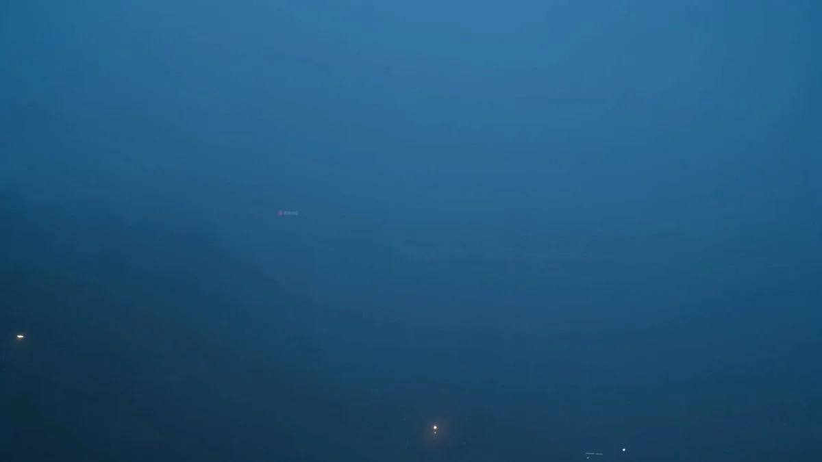 High crane shot descending through fog